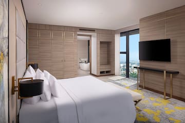 a bedroom with a large window and a large bed