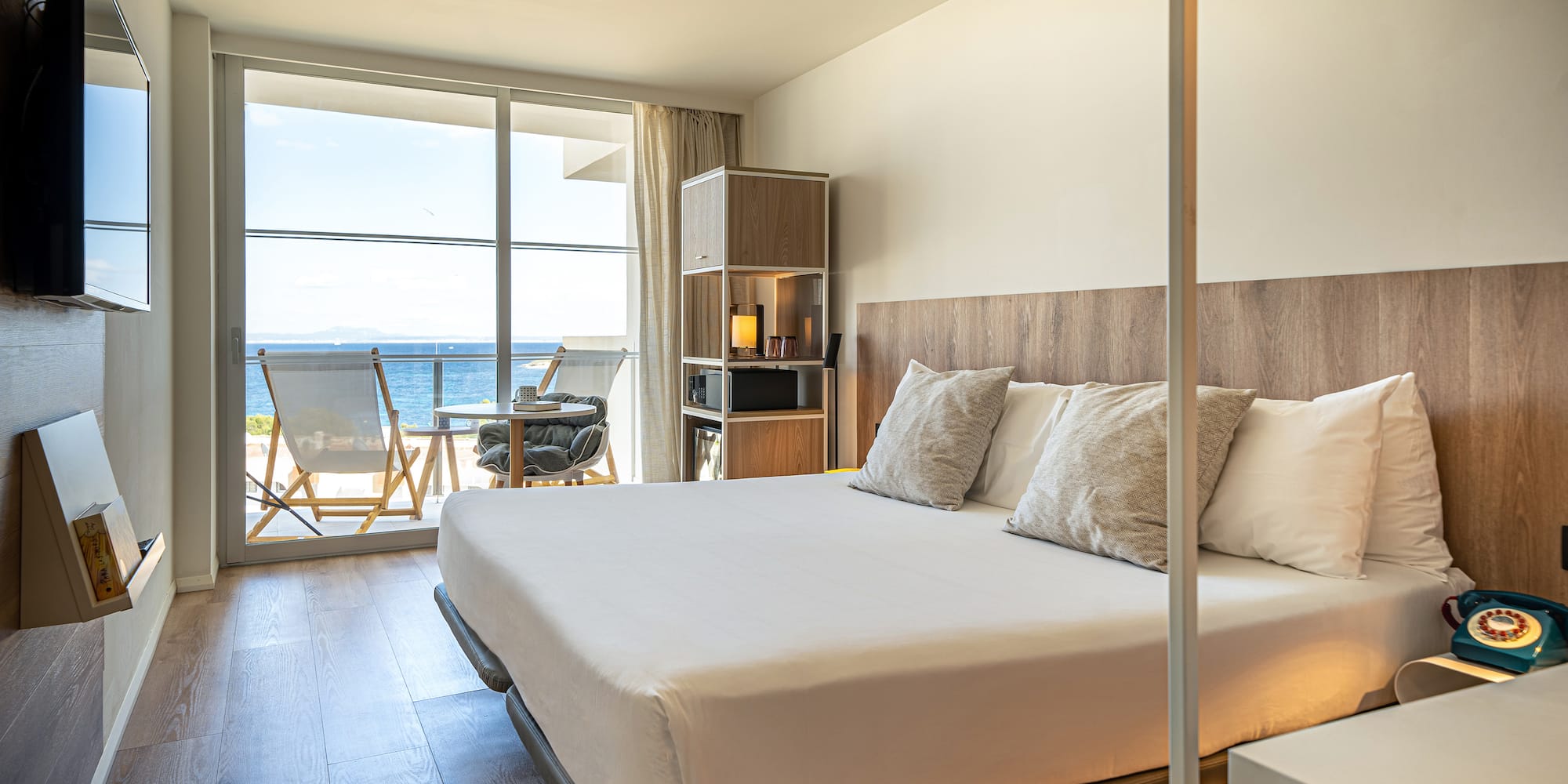 a bedroom with a large window overlooking the ocean