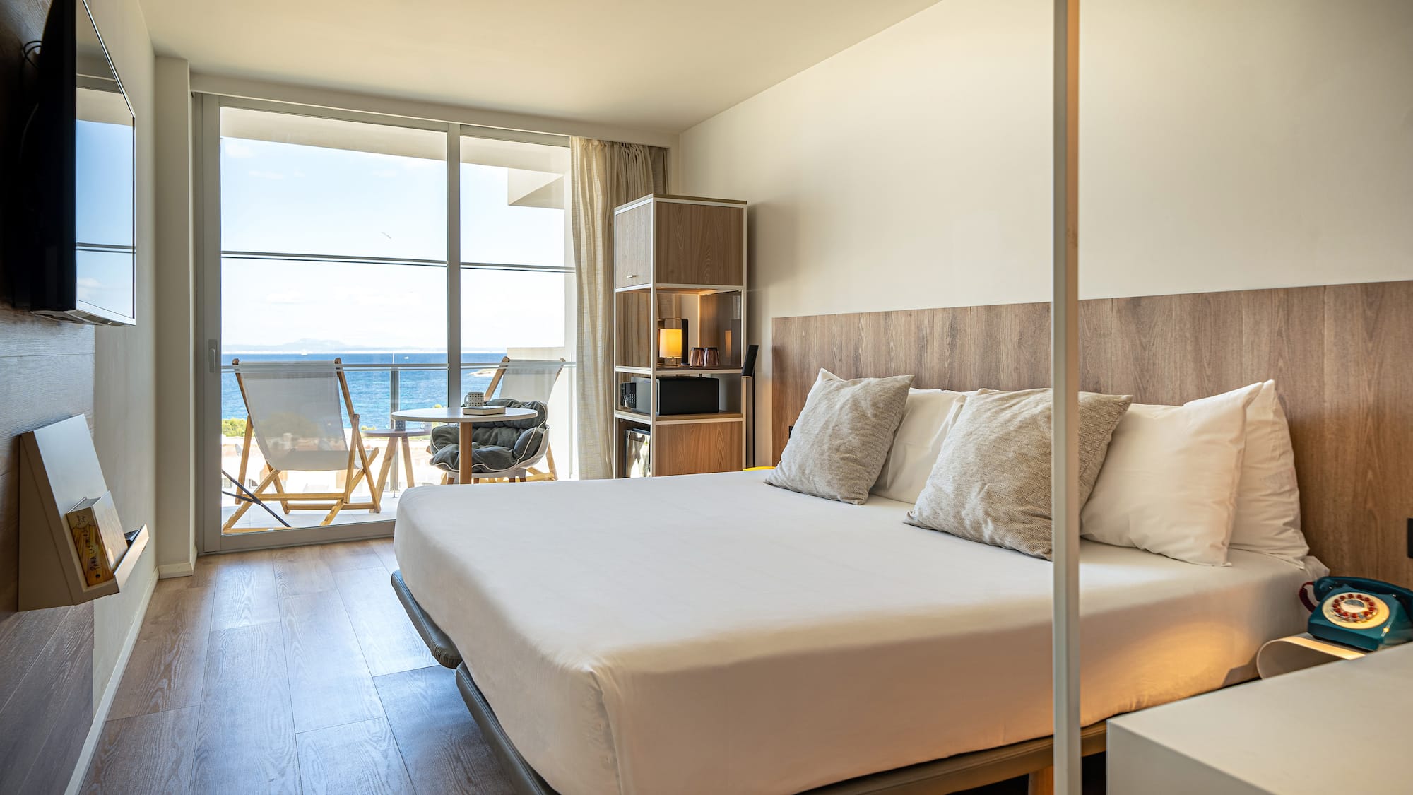 a bedroom with a large window overlooking the ocean