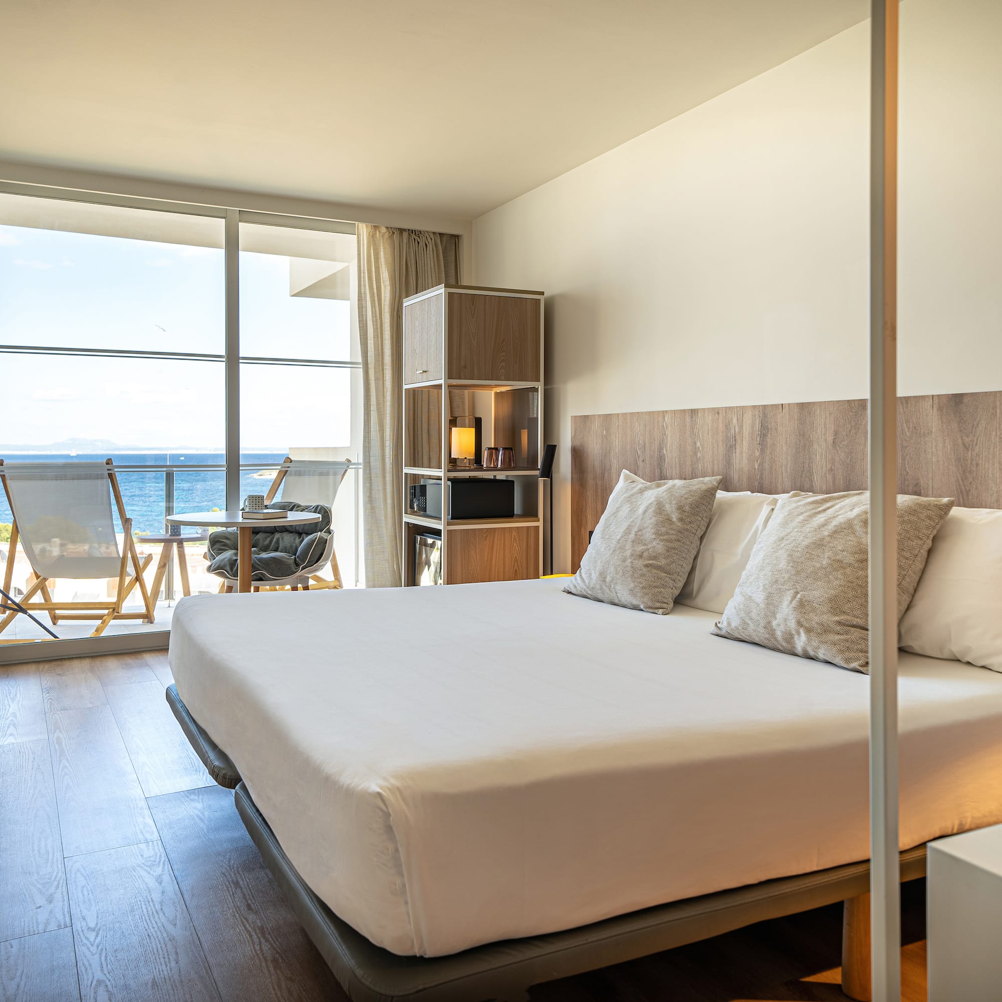 a bedroom with a large window overlooking the ocean