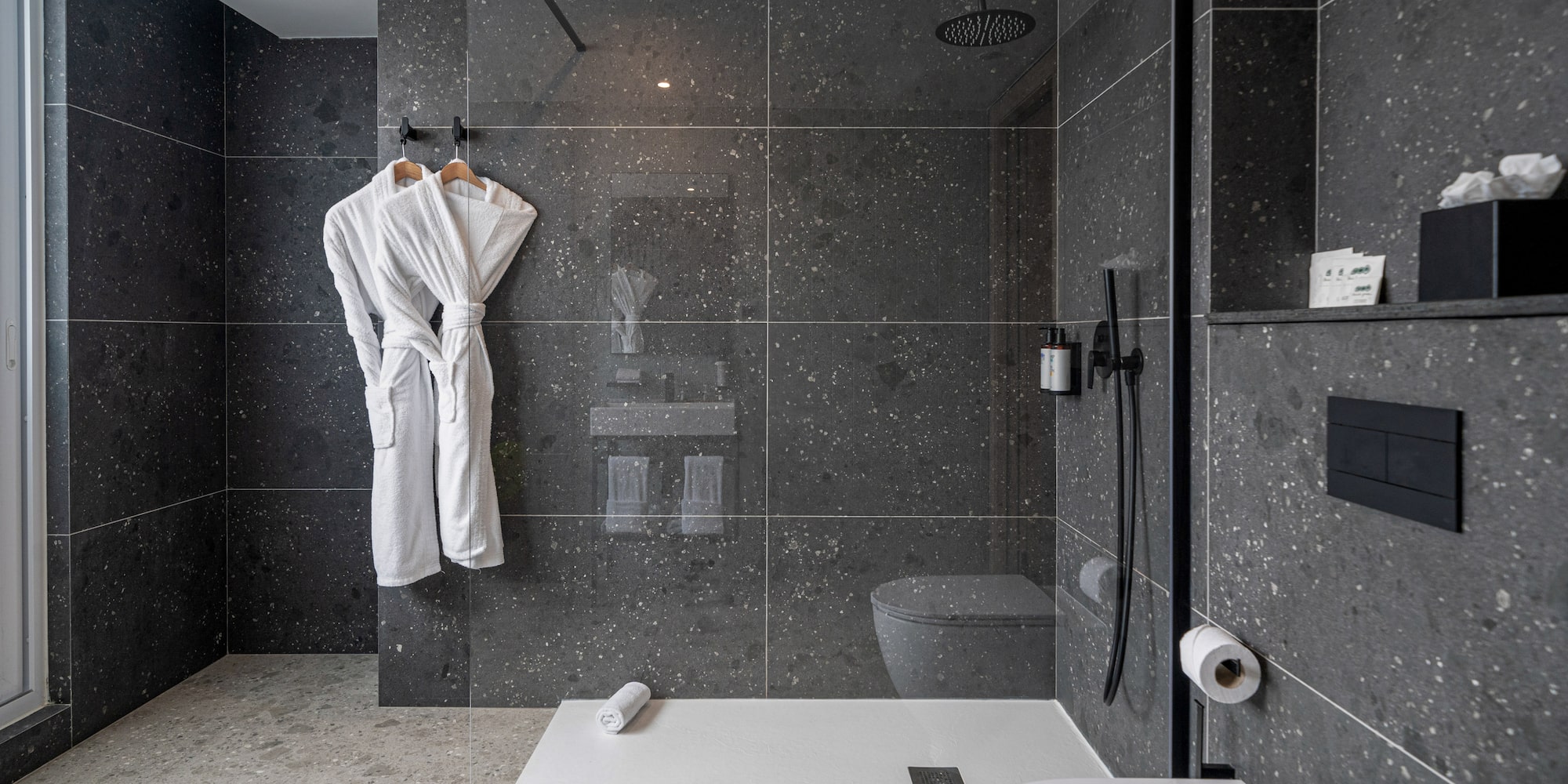 a bathroom with a shower and a bathrobe