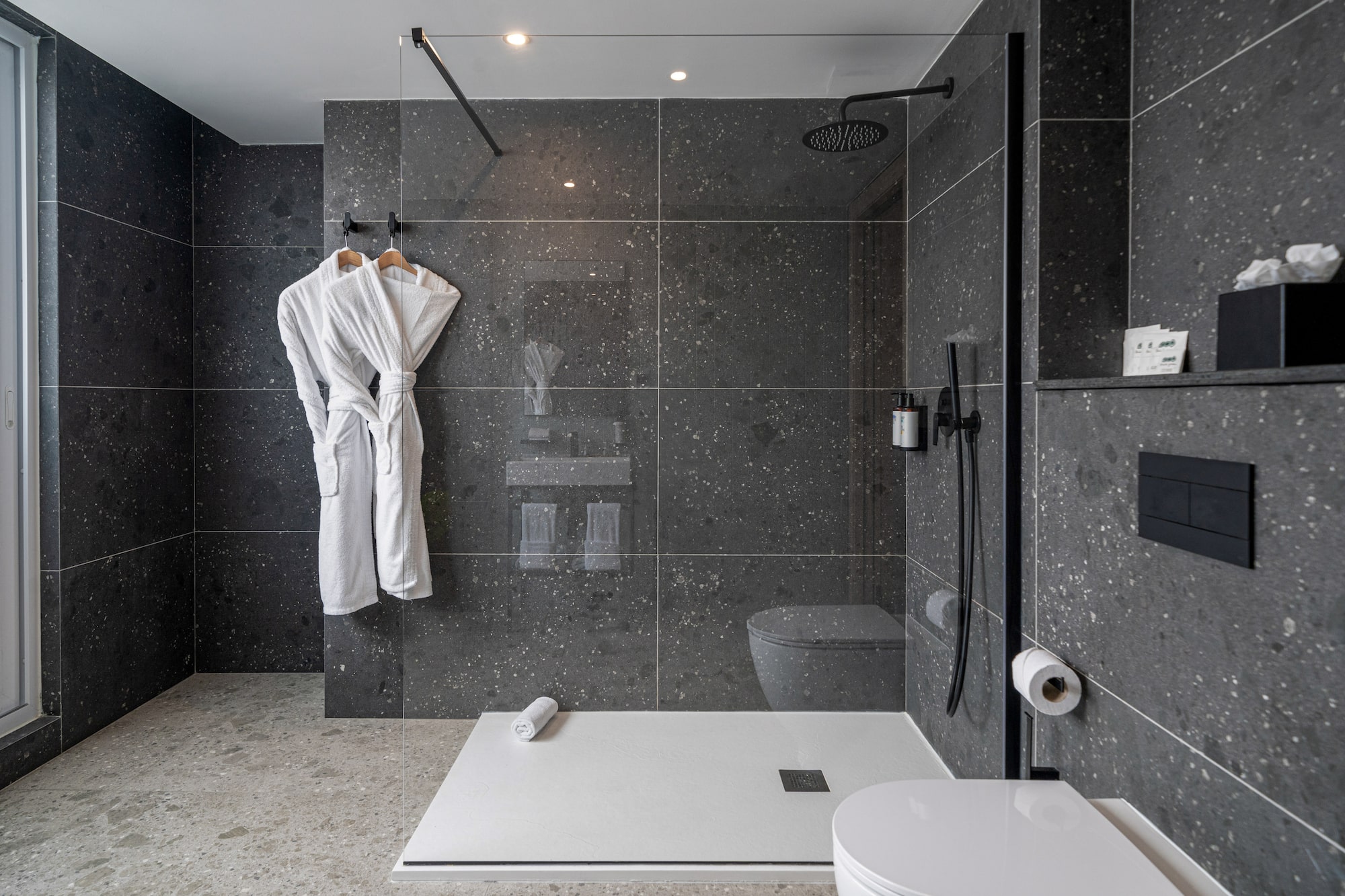 a bathroom with a shower and a bathrobe