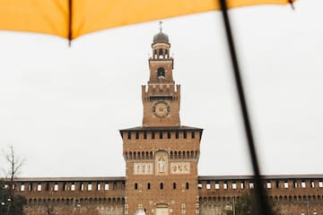 a large building with a clock tower and a fountain