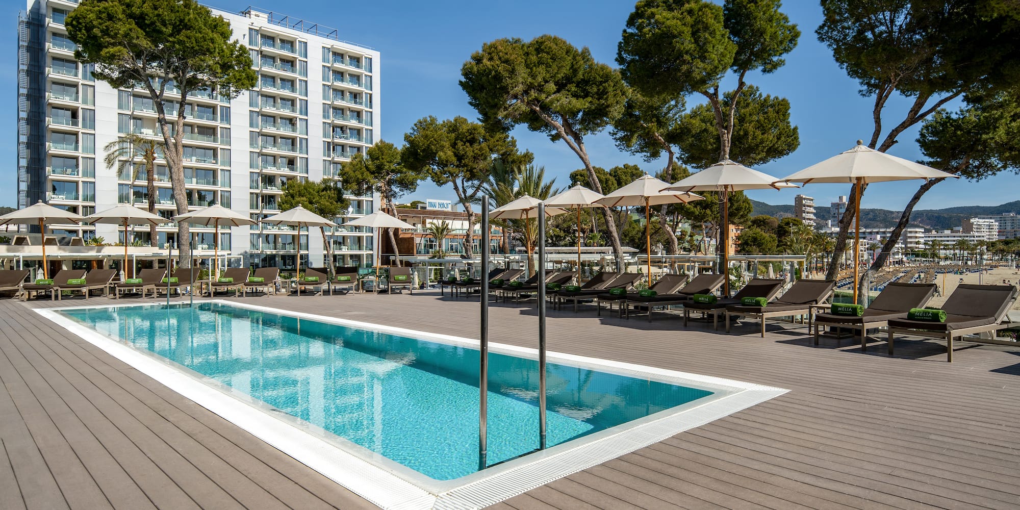 a pool with umbrellas and chairs on a deck
