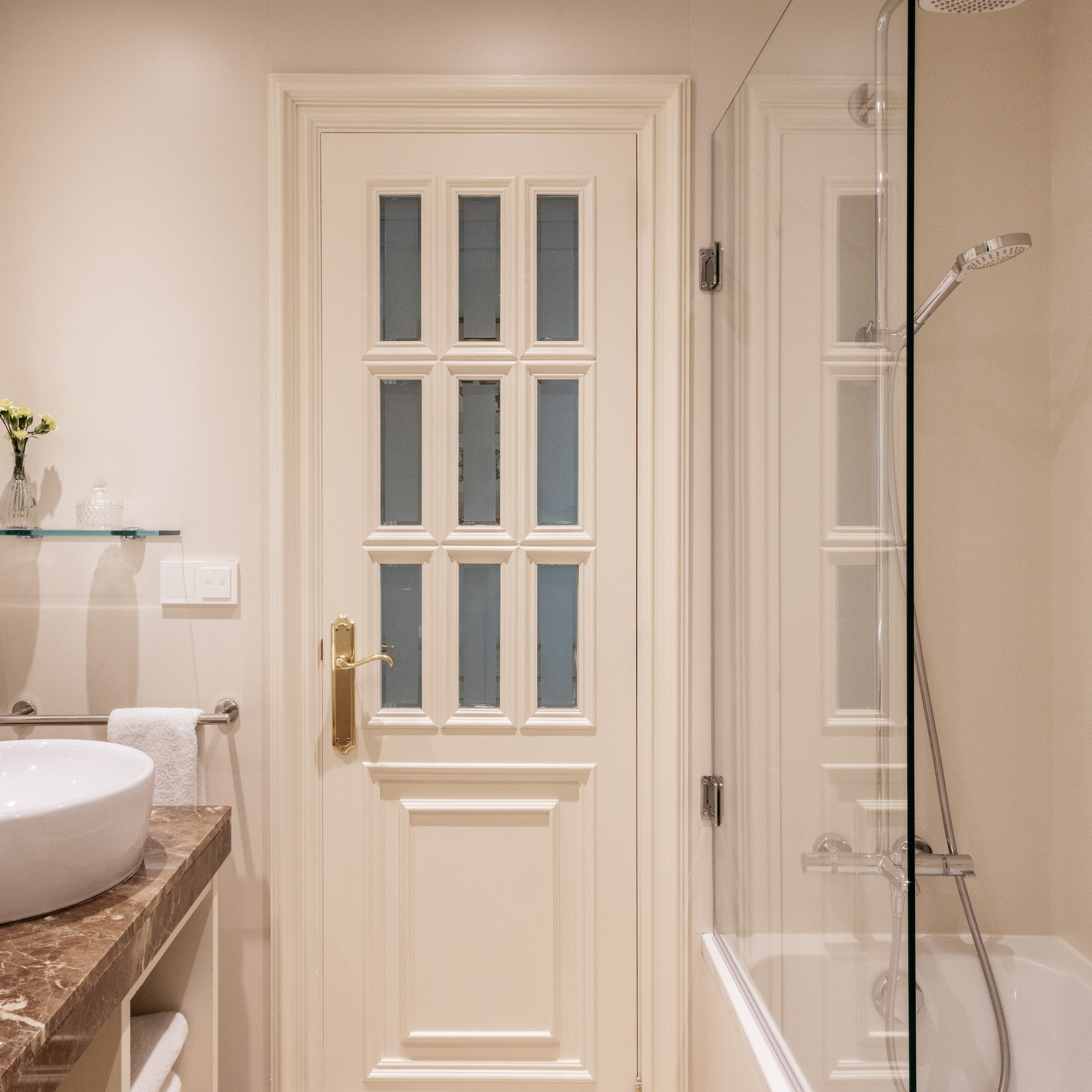 a bathroom with a glass shower and a door