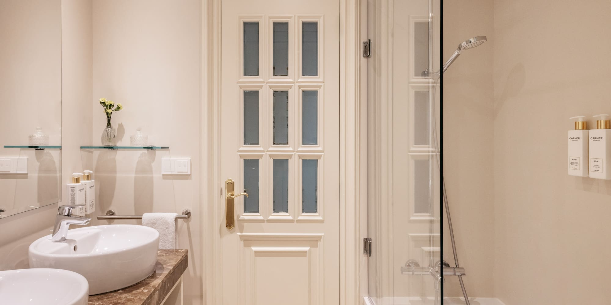 a bathroom with a glass shower and a door
