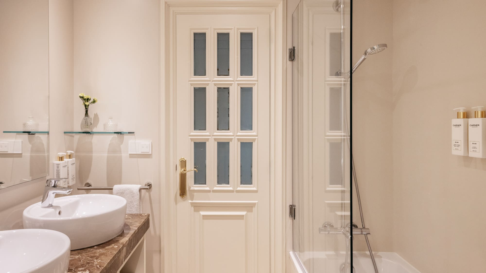 a bathroom with a glass shower and a door