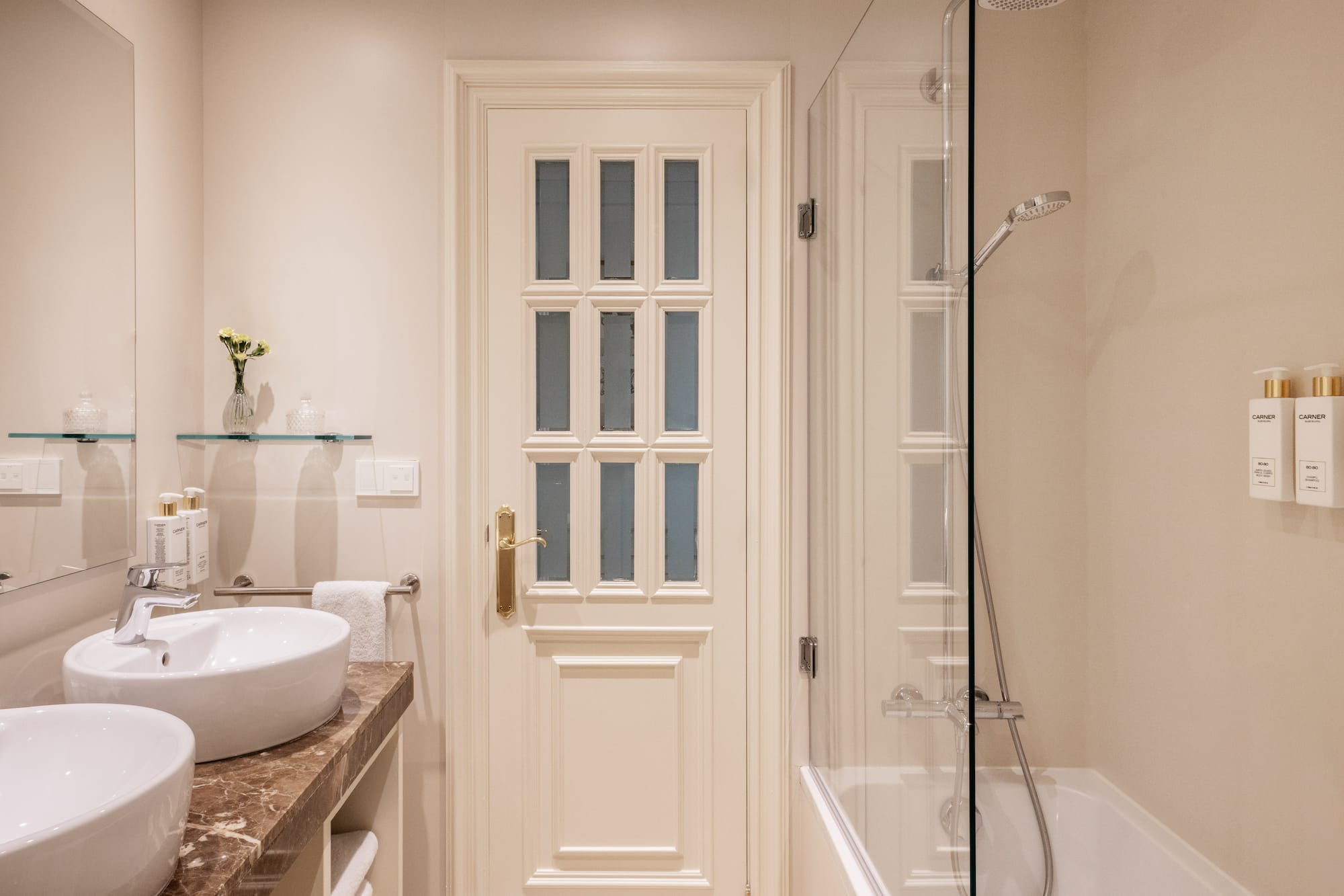 a bathroom with a glass shower and a door