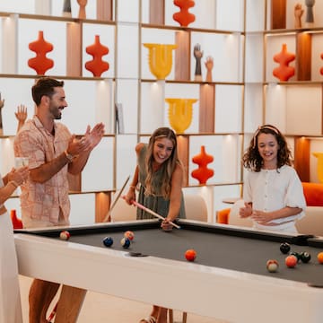 a group of people playing pool
