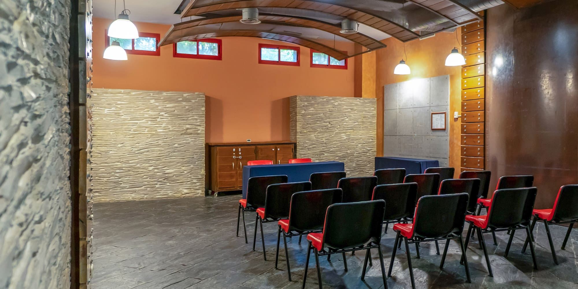 a room with chairs and a stone wall