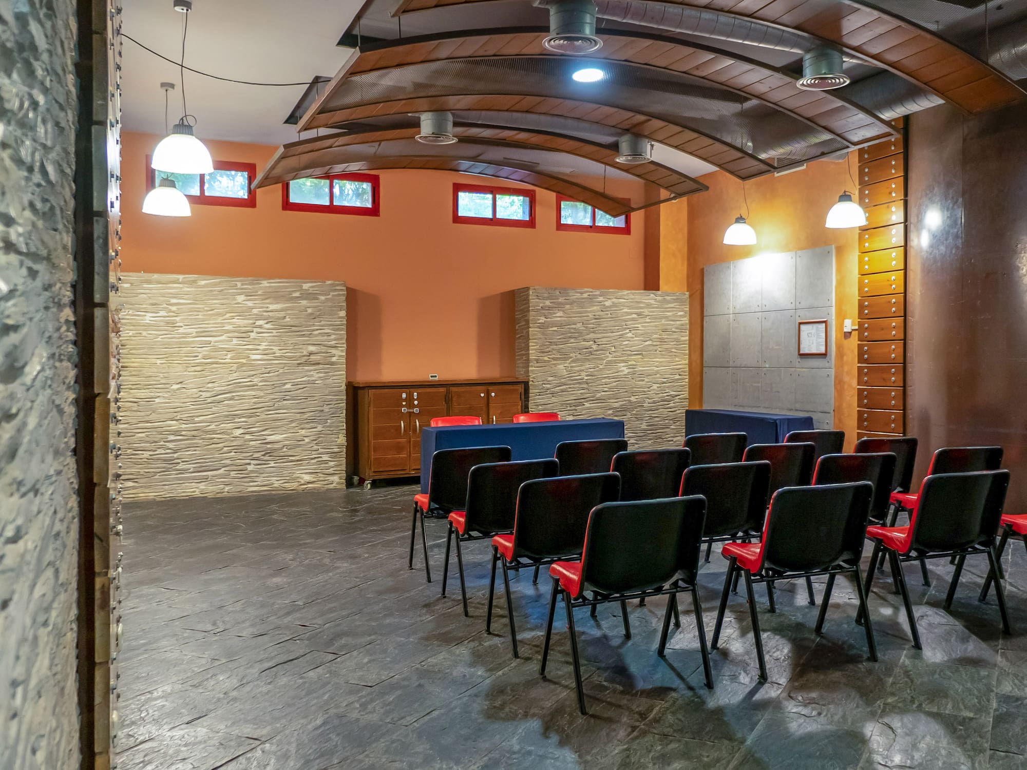 a room with chairs and a stone wall