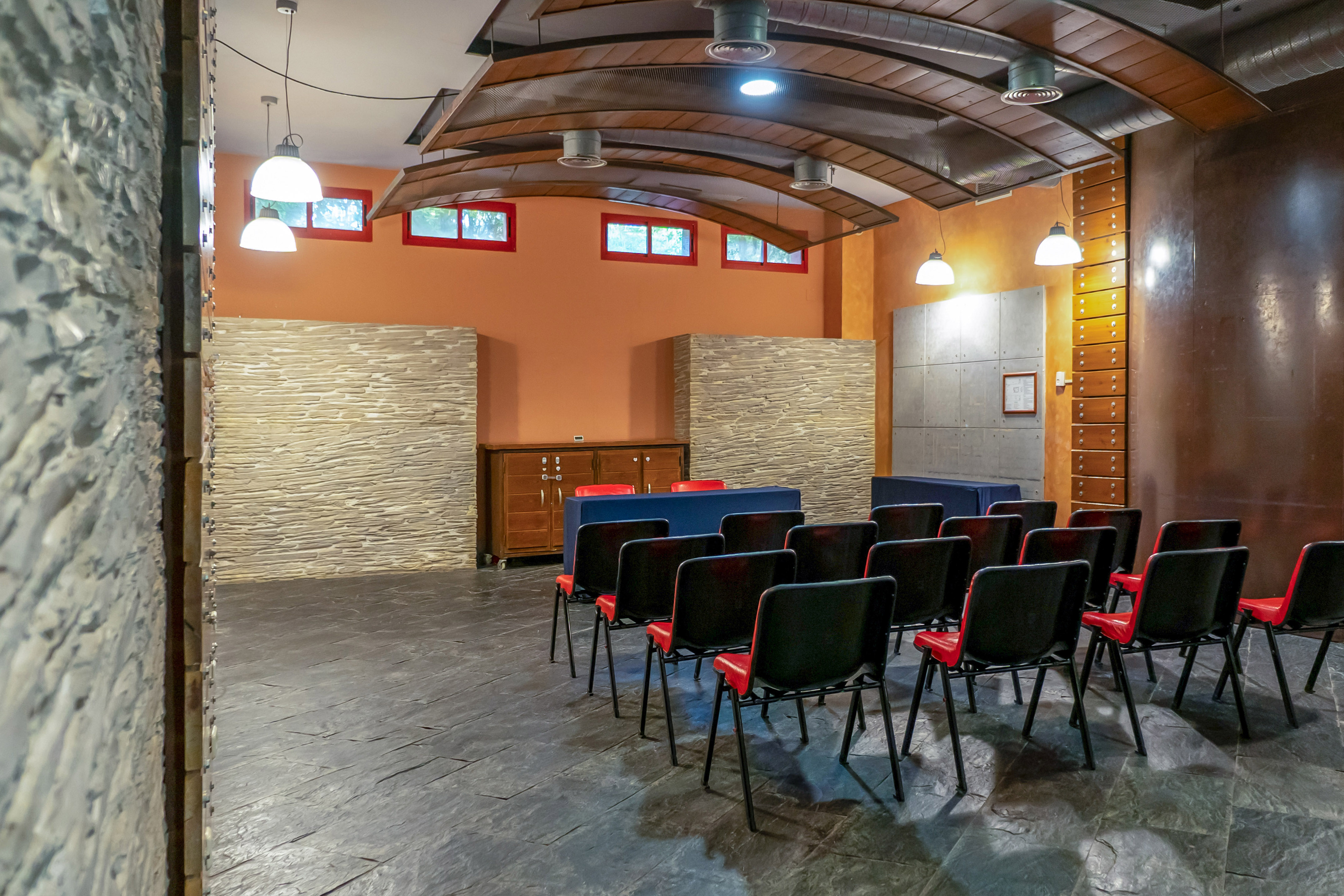 a room with chairs and a stone wall