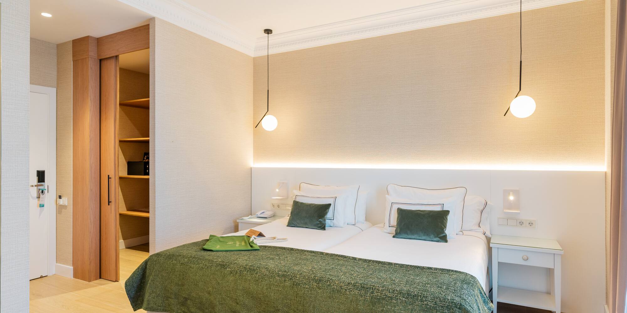 a bedroom with a green blanket and a light fixture