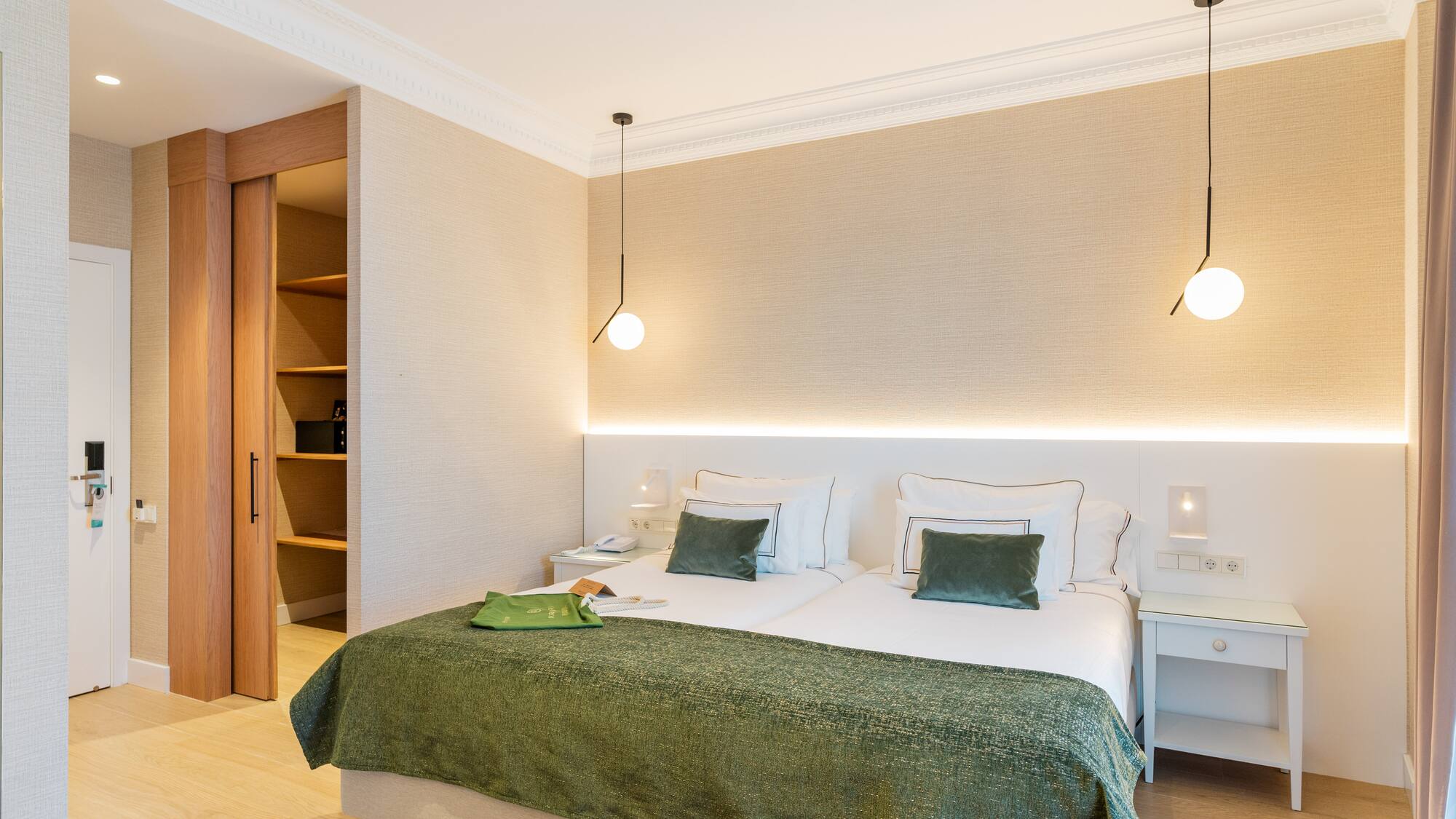 a bedroom with a green blanket and a light fixture