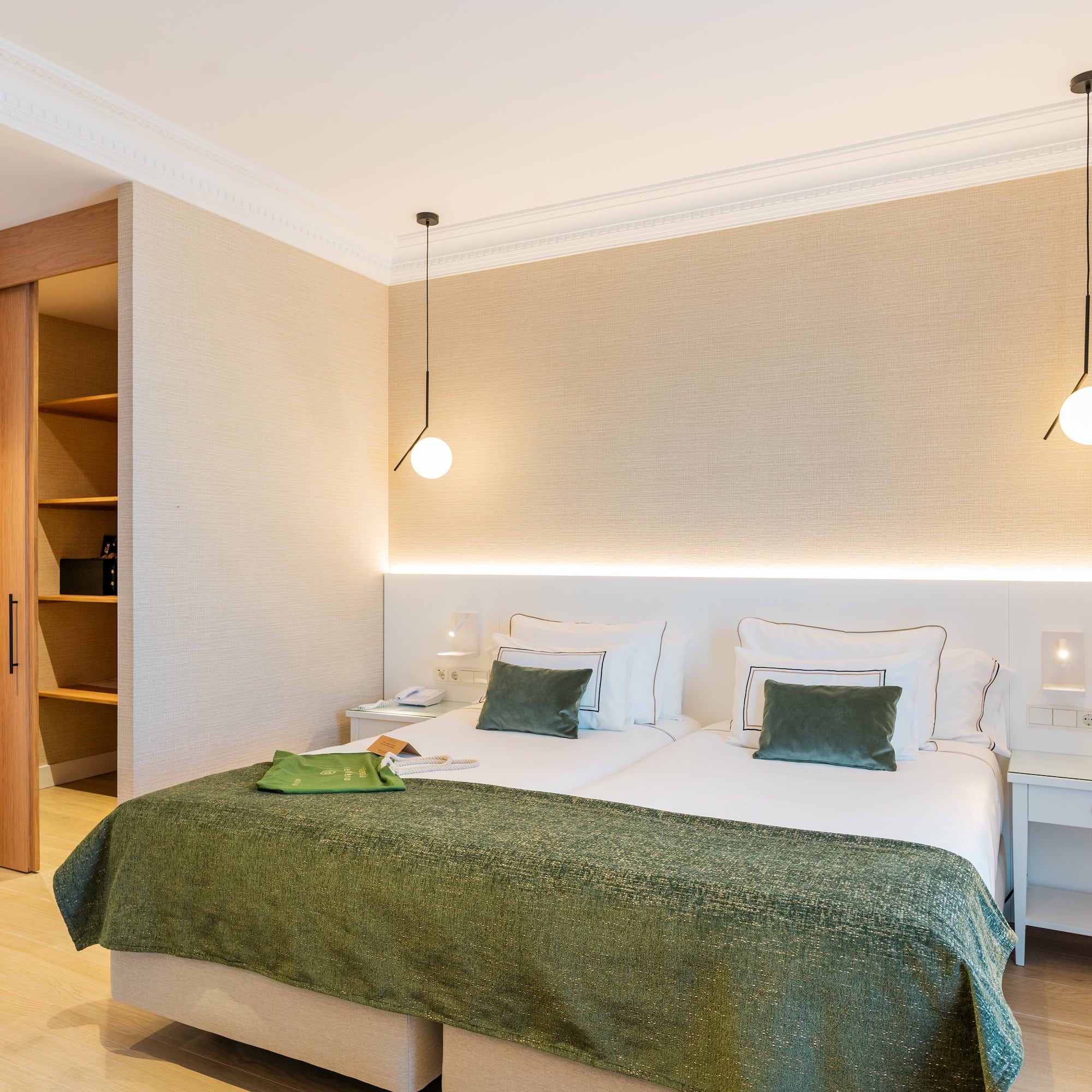 a bedroom with a green blanket and a light fixture