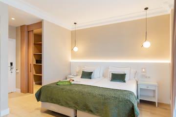 a bedroom with a green blanket and a light fixture