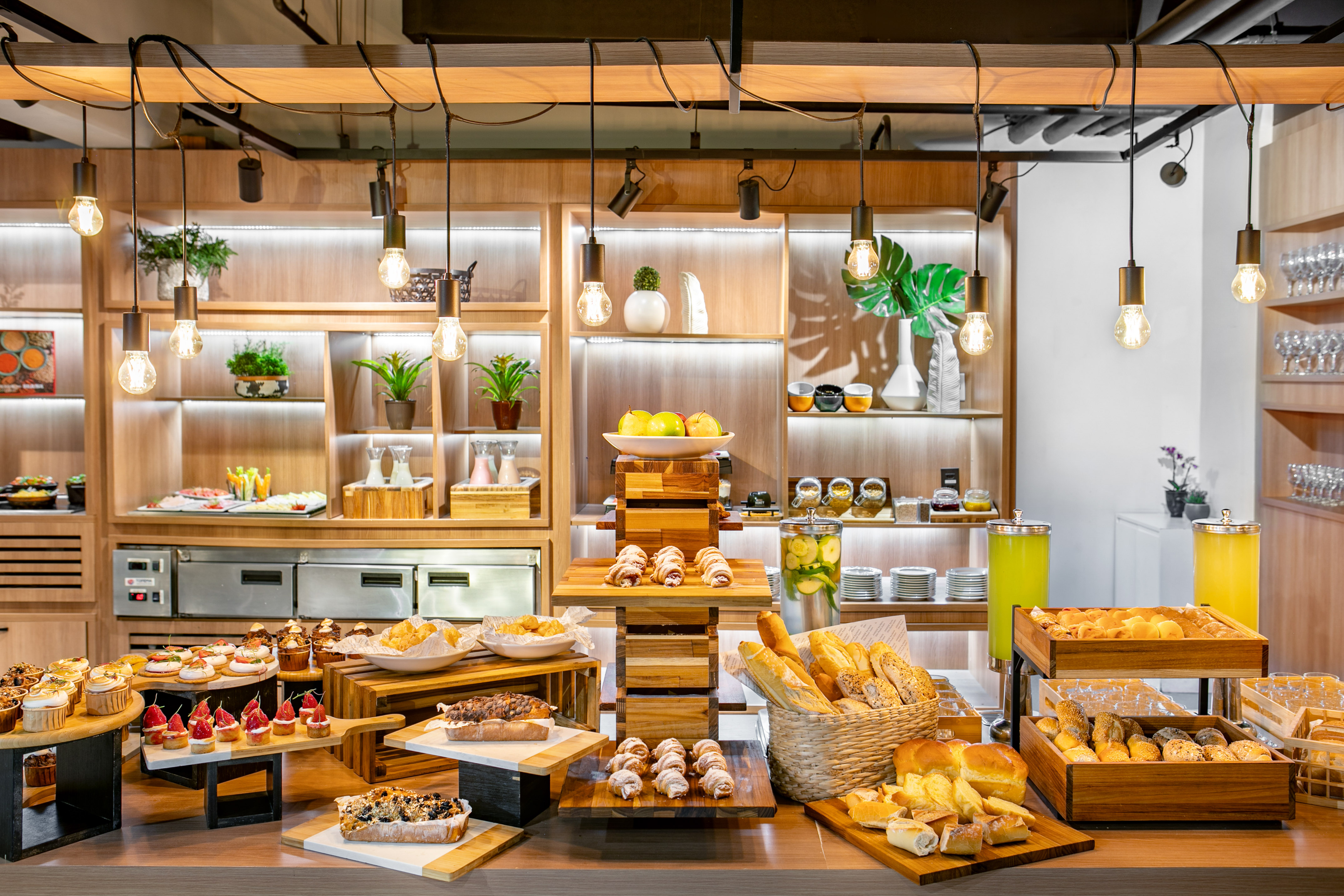 Hotel breakfast buffet with pastries, breads, fresh fruit, and juices.