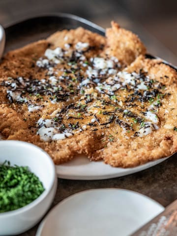 a plate of food with bowls of sauces and a grater