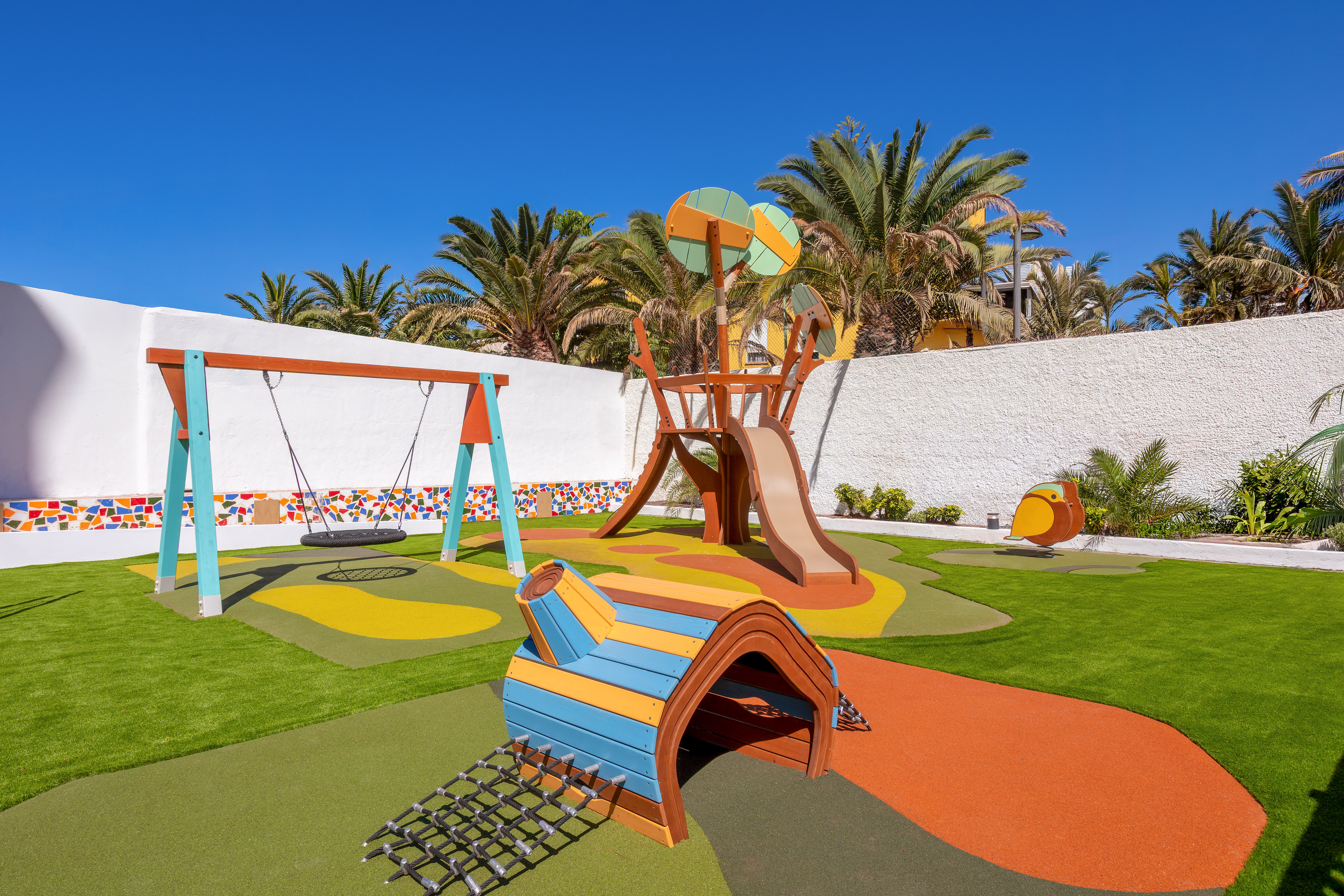 Colorful outdoor children's playground with swing, slide, and tunnel.