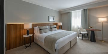 a bedroom with a bed and a table and chairs