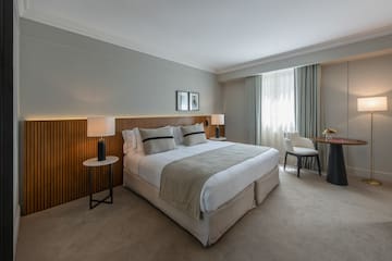 a bedroom with a bed and a table and chairs