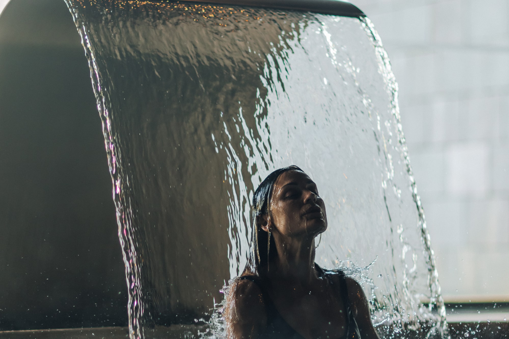 a woman under a waterfall