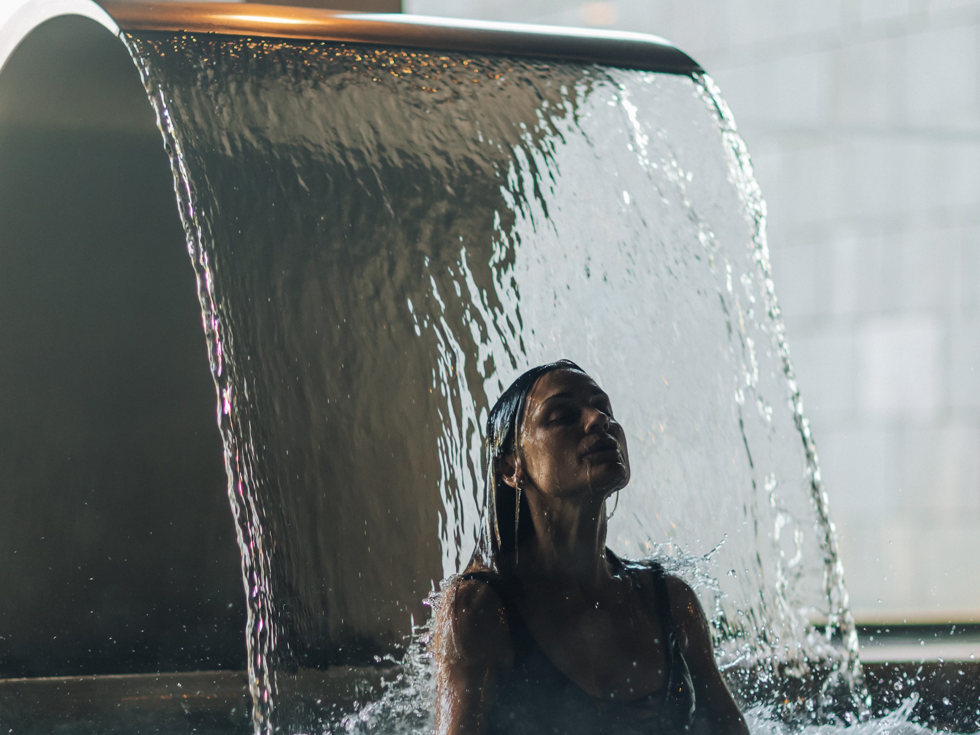 a woman under a waterfall