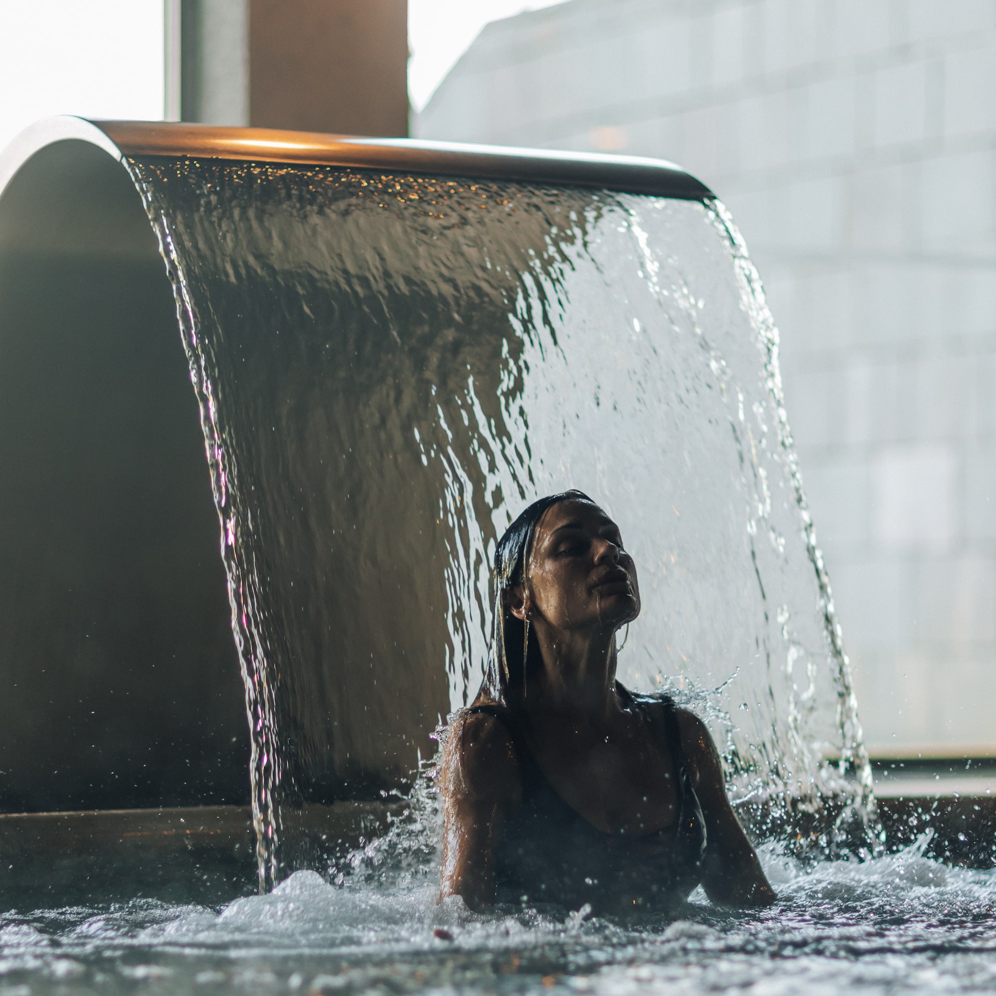 a woman under a waterfall