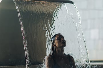 a woman under a waterfall