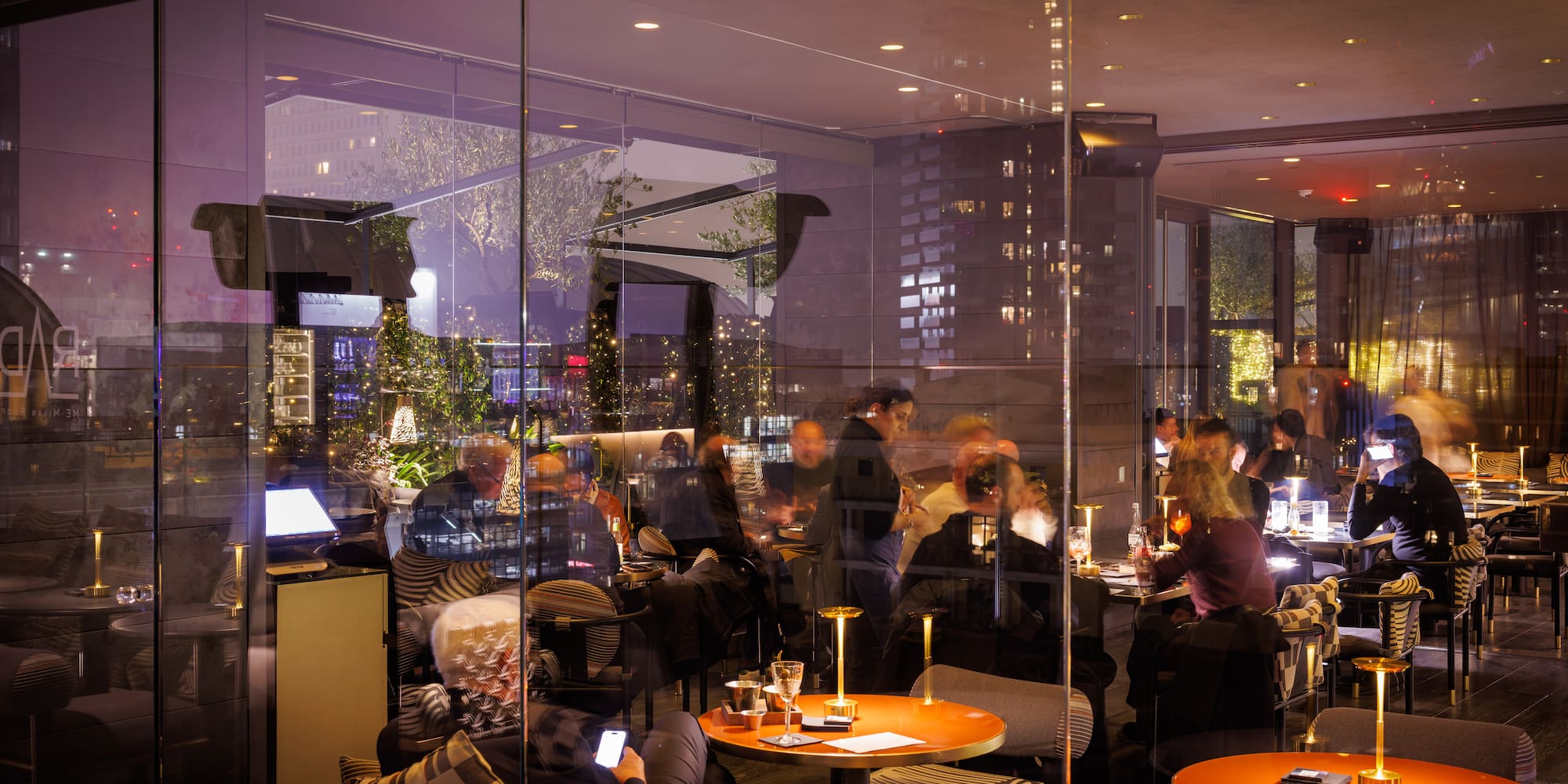 a group of people sitting at tables in a restaurant