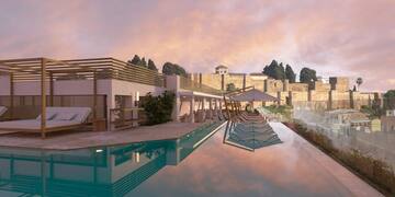 a pool with a building and a stone wall