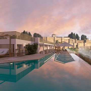 a pool with a building and a stone wall