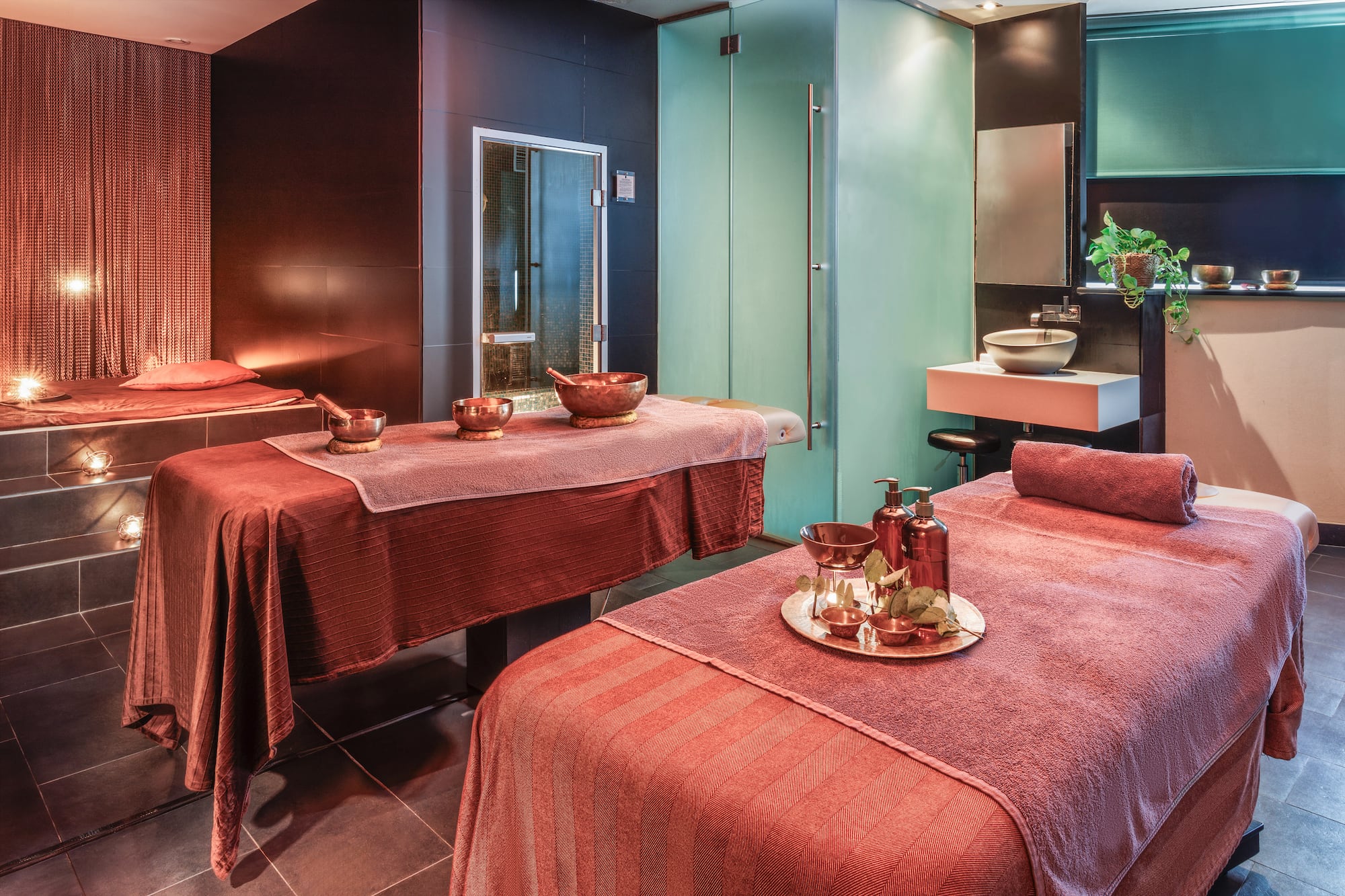 Spa relajante con dos camillas de masaje, velas y decoración zen.