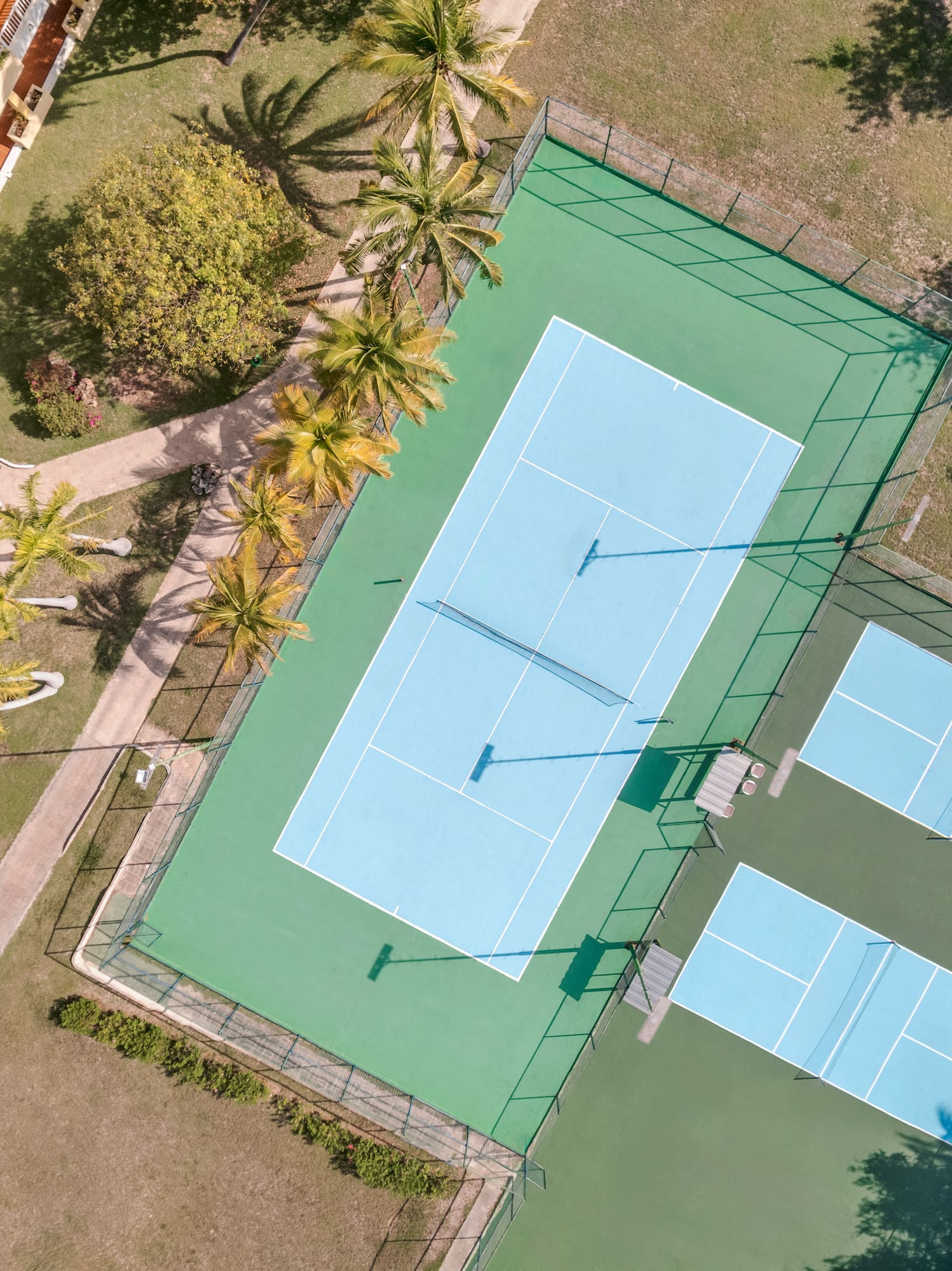a tennis court with trees and grass