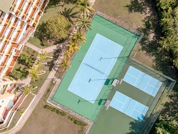 a tennis court with trees and grass