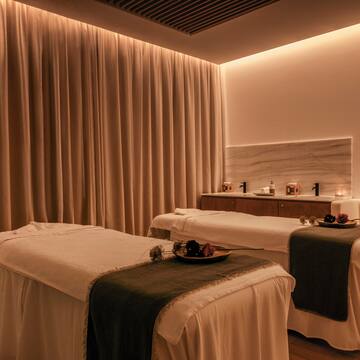 a massage room with white beds and a light fixture