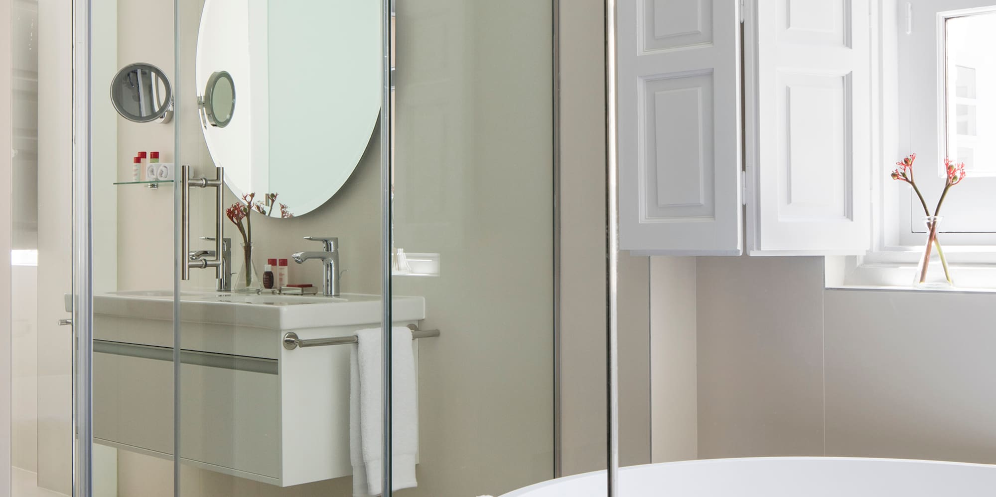 a bathroom with a round mirror and a tub