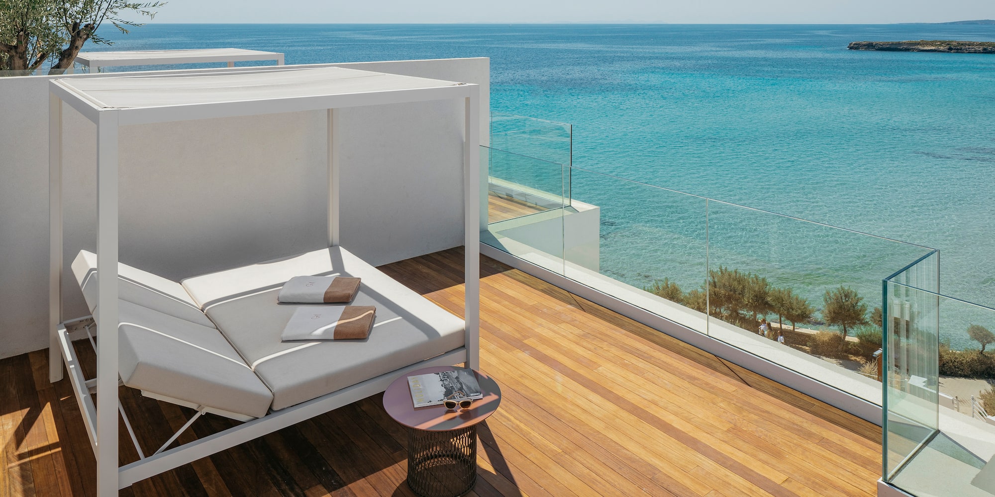 a deck with a couch and a table overlooking the ocean