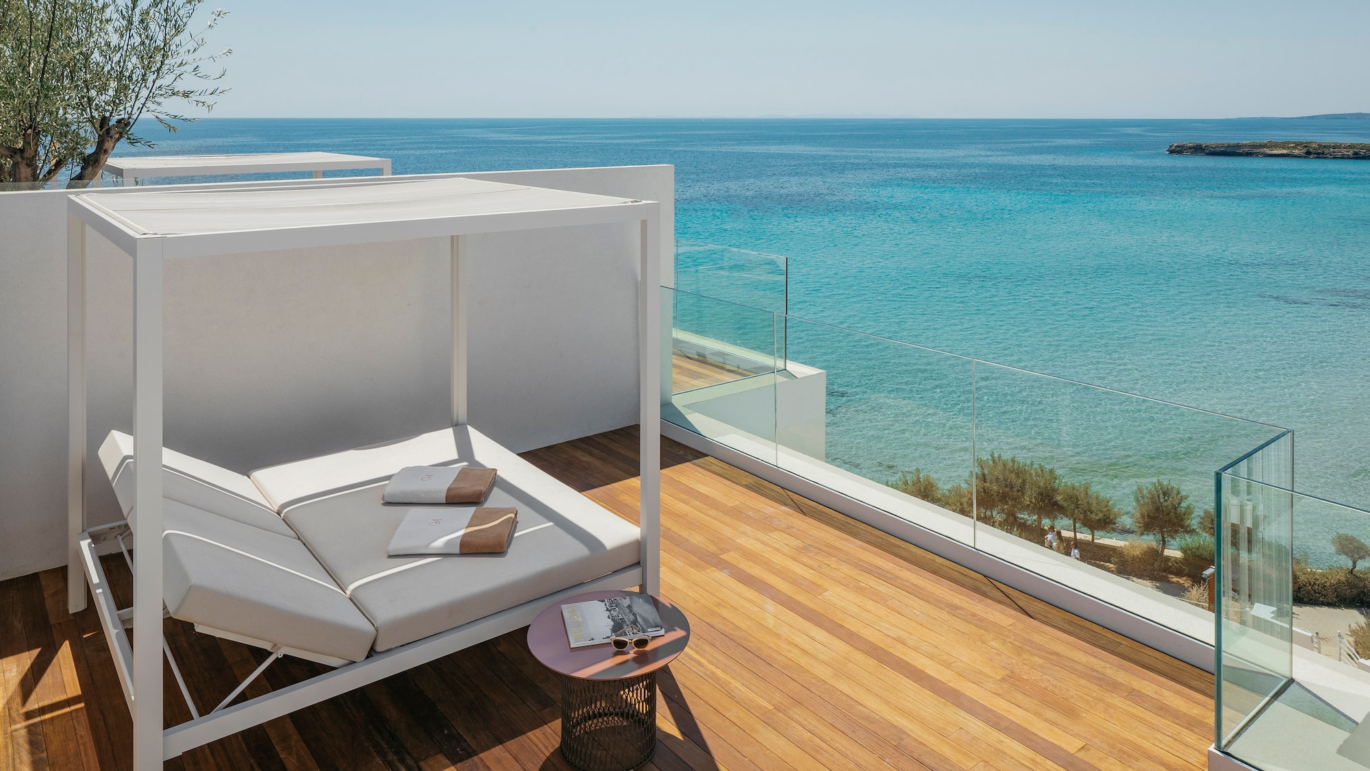 a deck with a couch and a table overlooking the ocean