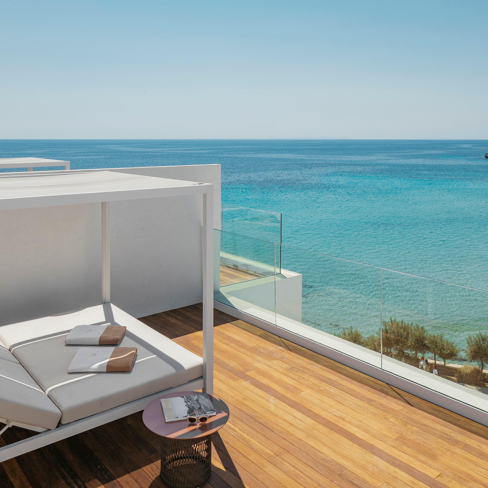 a deck with a couch and a table overlooking the ocean
