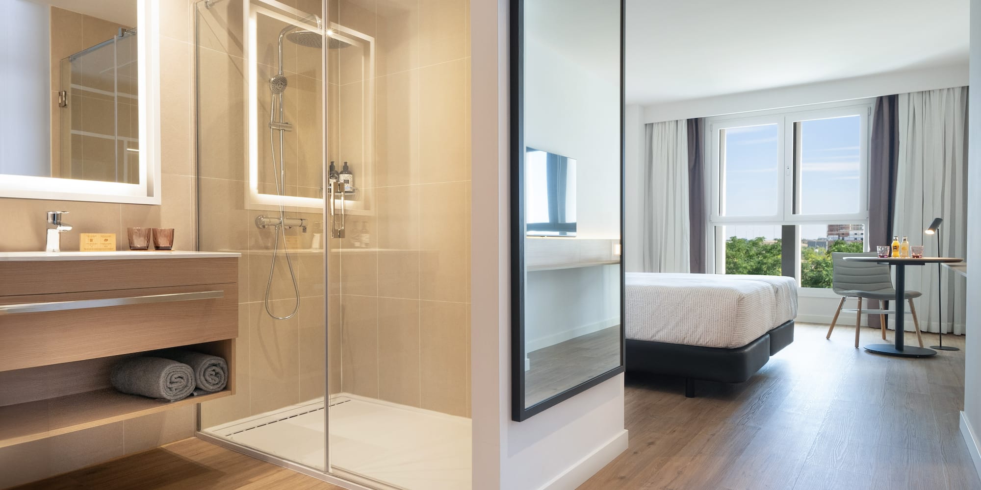 a bathroom with a glass shower and a bed