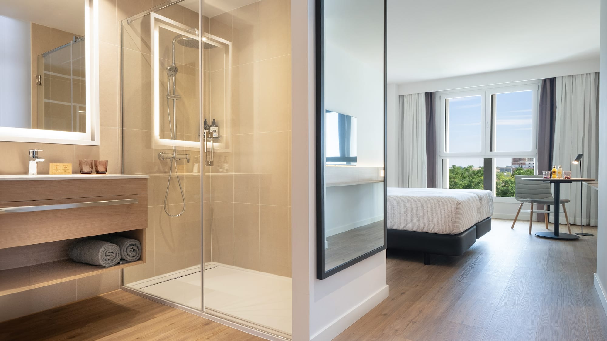 a bathroom with a glass shower and a bed