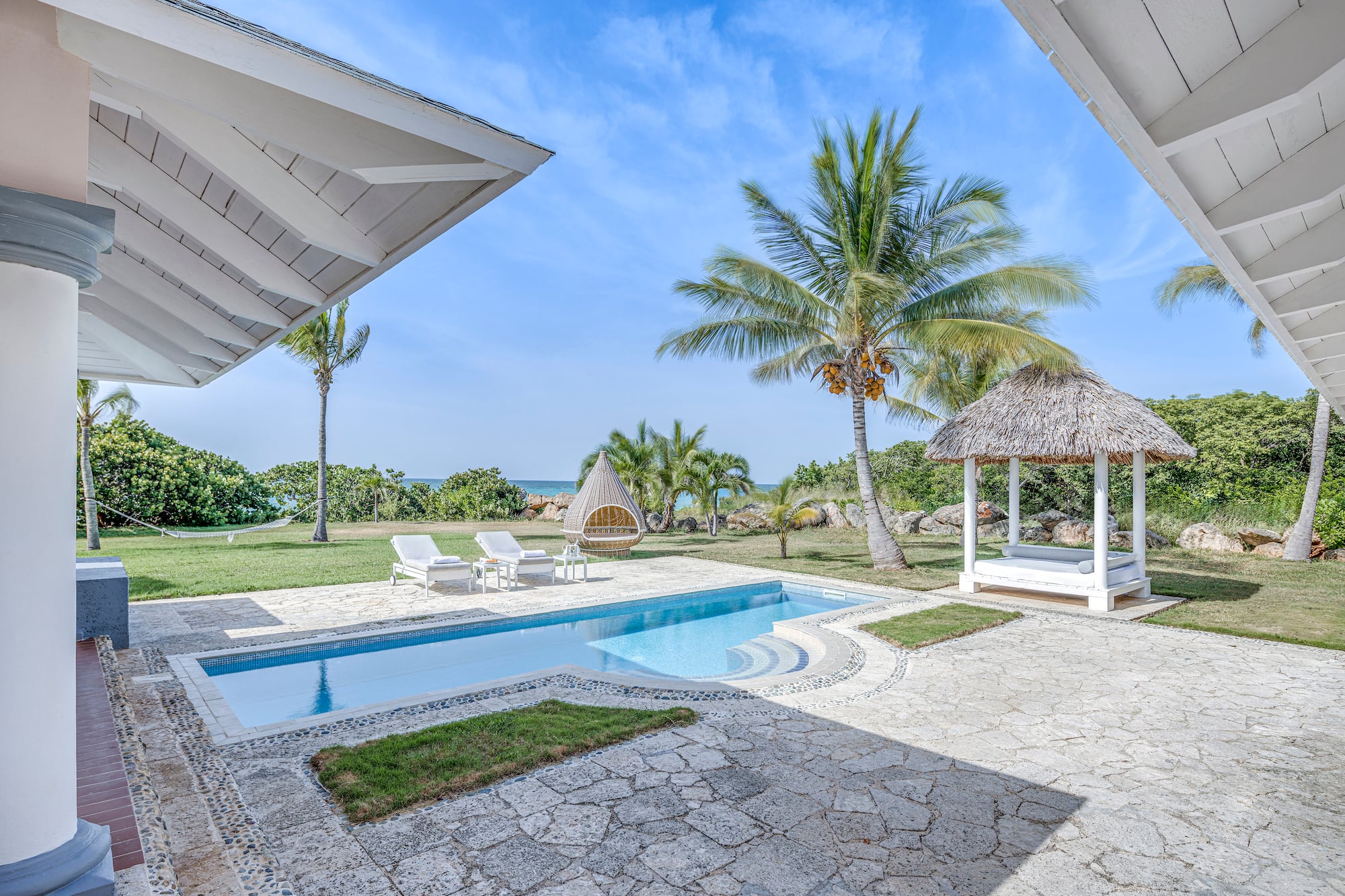 a pool and a gazebo with palm trees