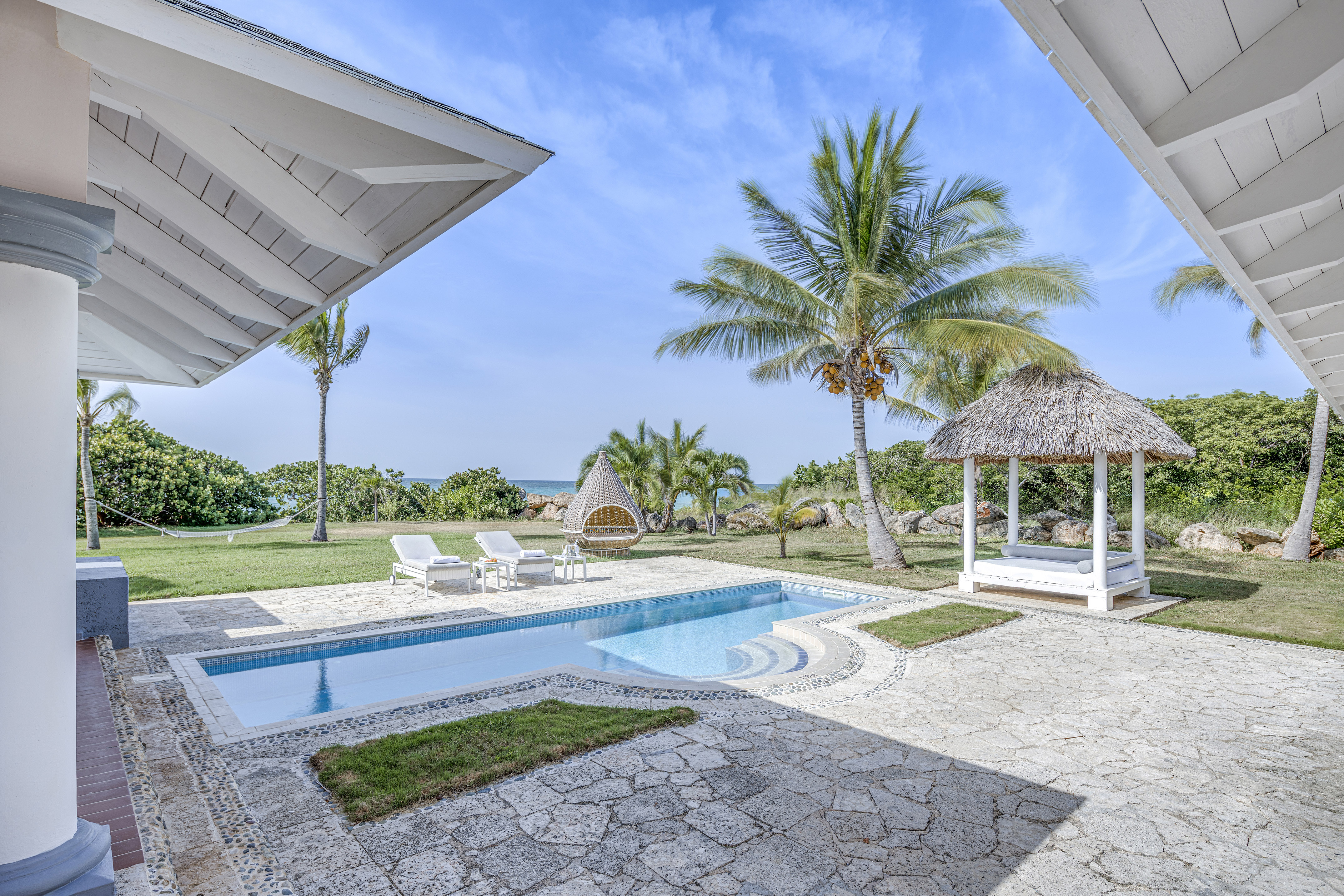 a pool and a gazebo with palm trees