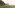a man and woman walking on a grassy hill