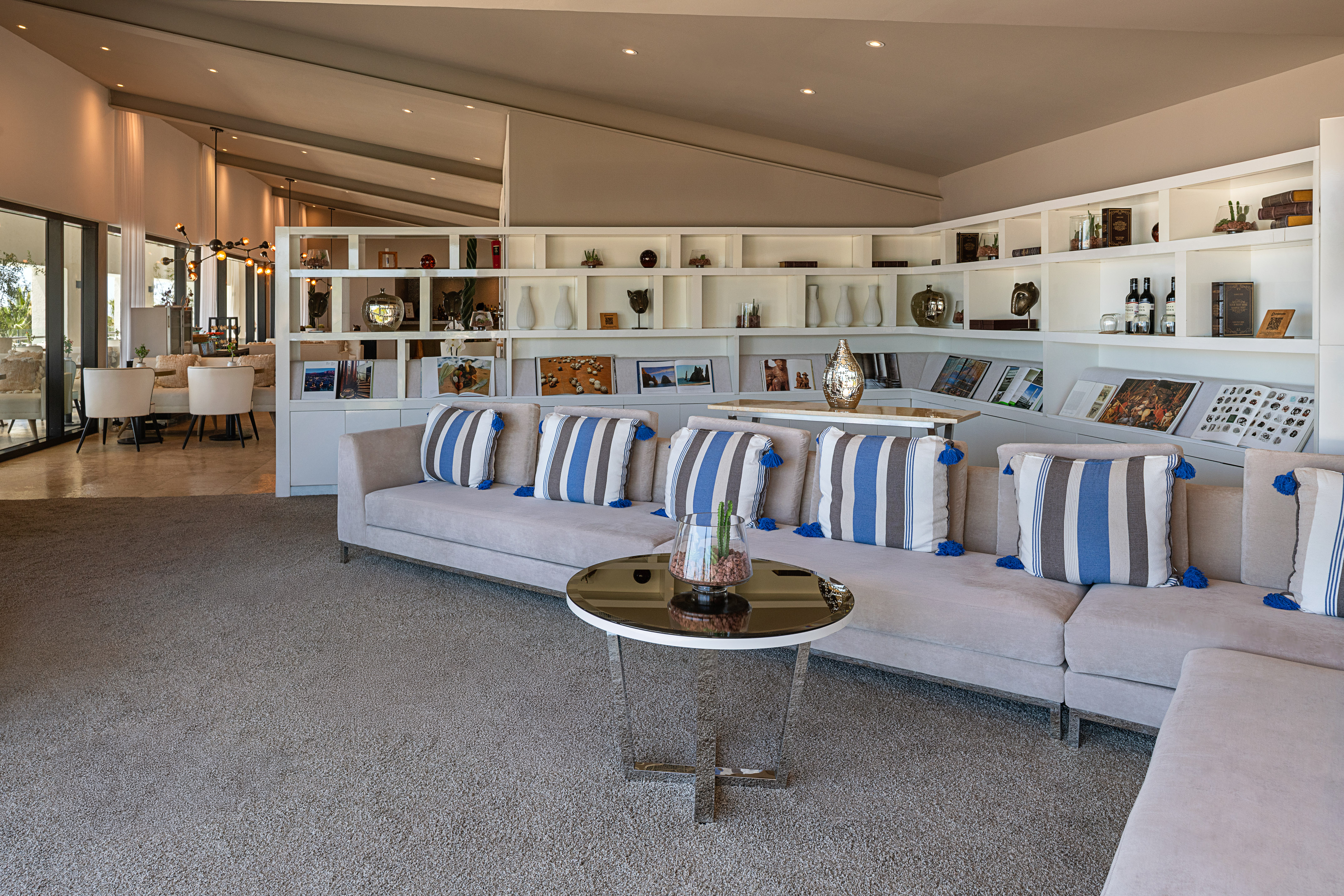 Modern living room with sectional sofa, striped cushions, white built-in shelves.