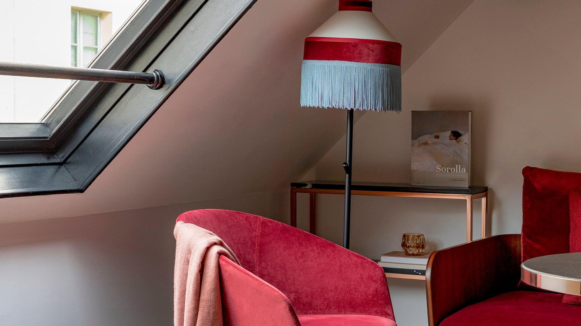 a room with a red couch and a lamp