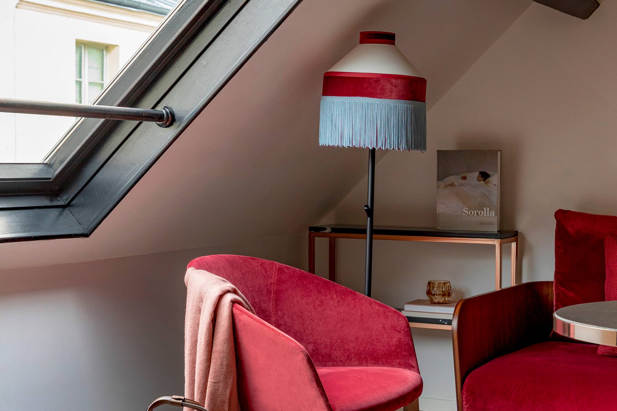 a room with a red couch and a lamp