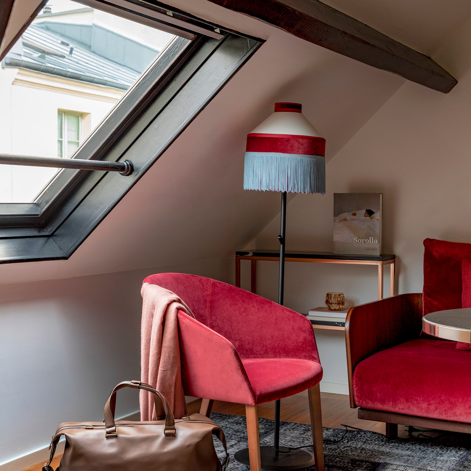 a room with a red couch and a lamp
