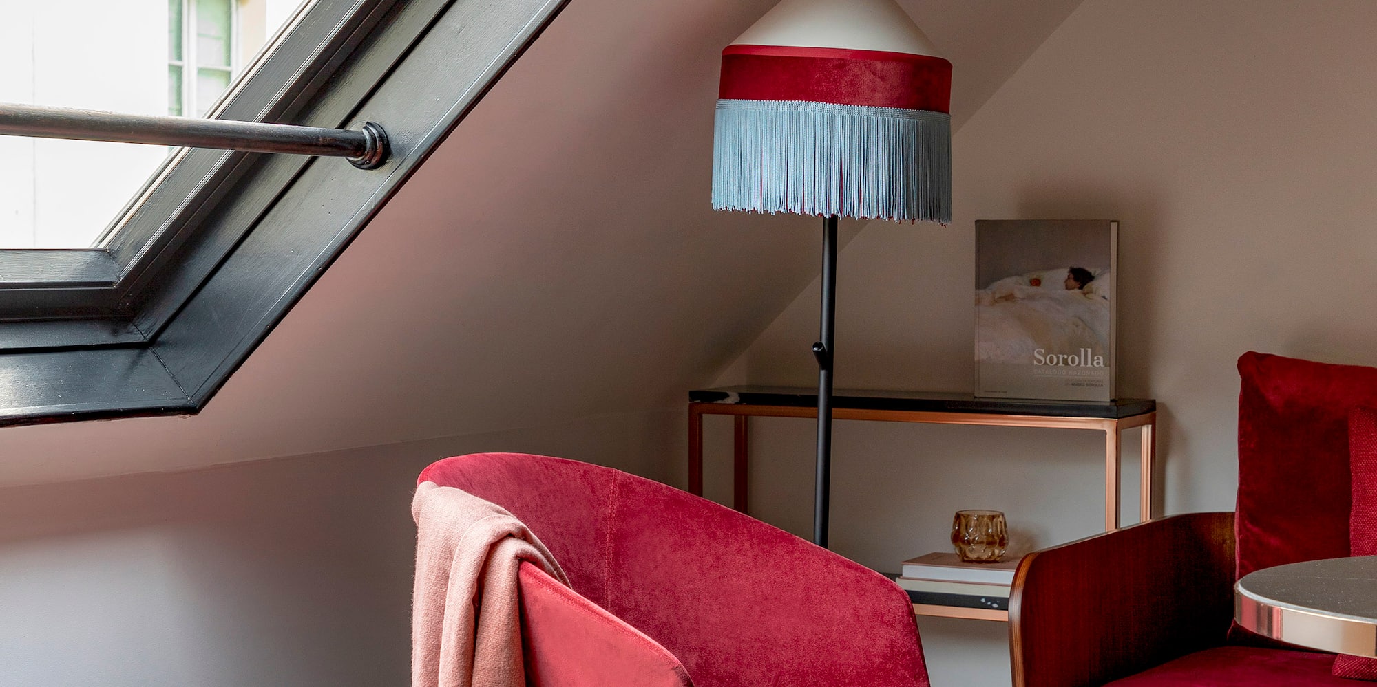 a room with a red couch and a lamp